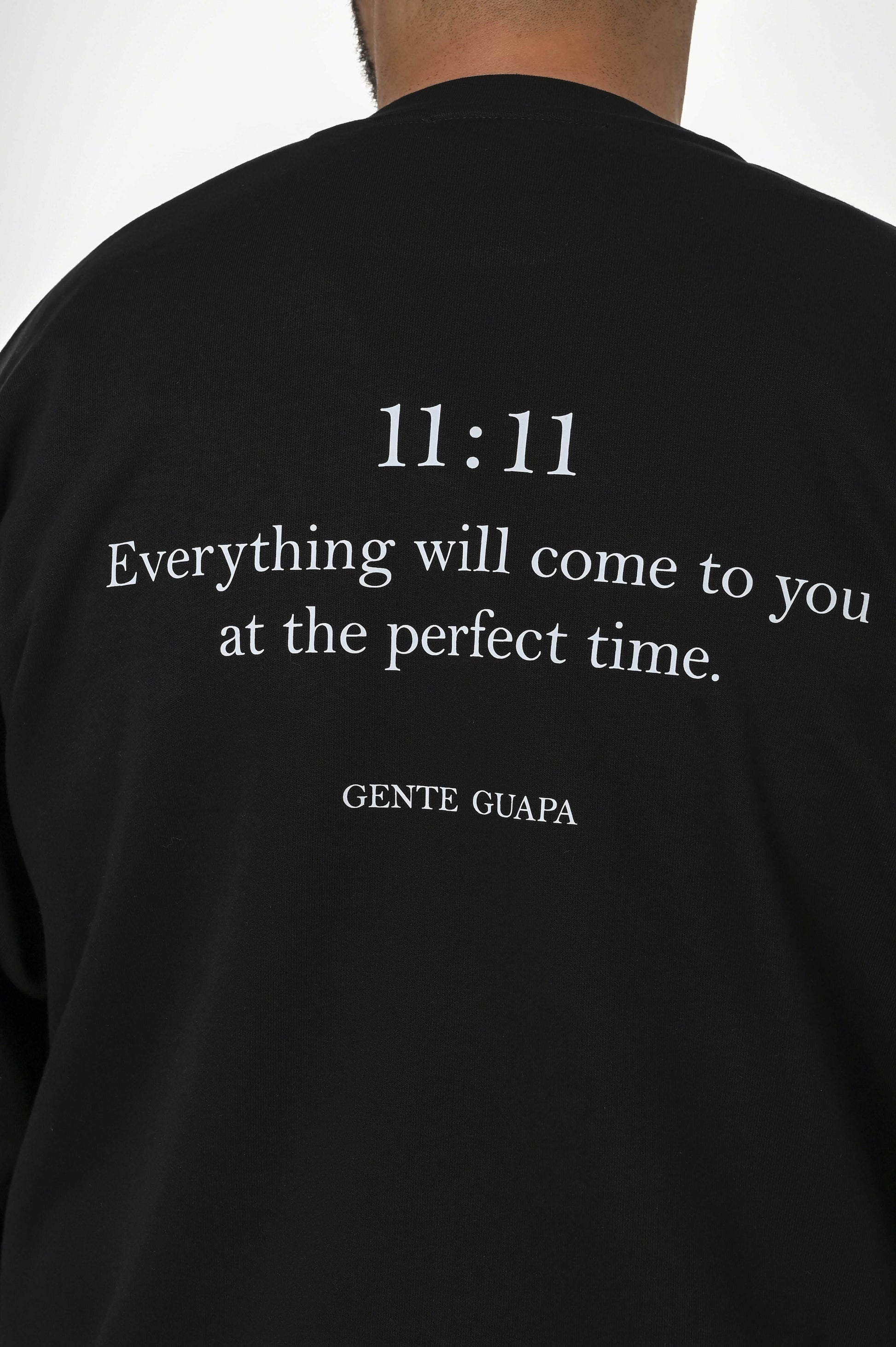 Gente Guapa black hoodie with “11:11 Everything will come to you at the perfect time” print — unisex streetwear back view